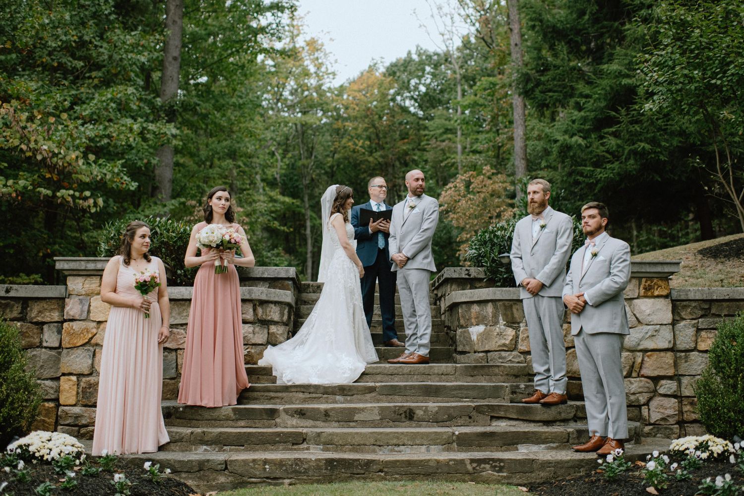 ceremony altar with bridesmaids in pink dresses at strong mansion outdoor gardens