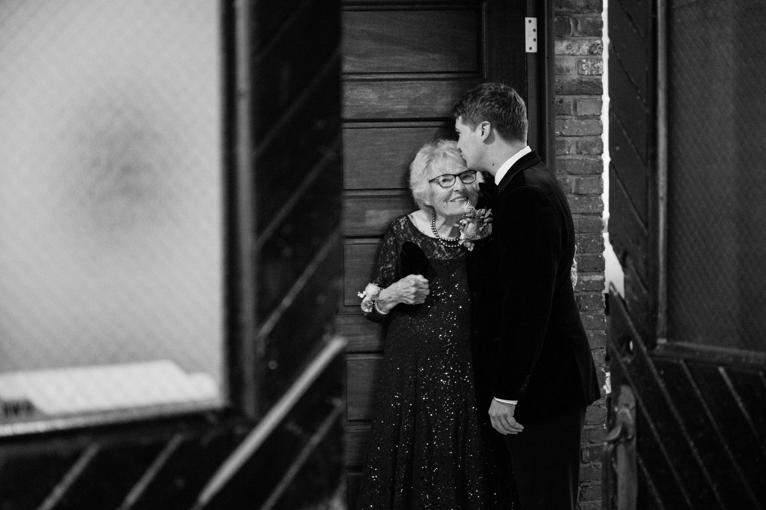 Intimate black and white moment captured between couple in formal attire.