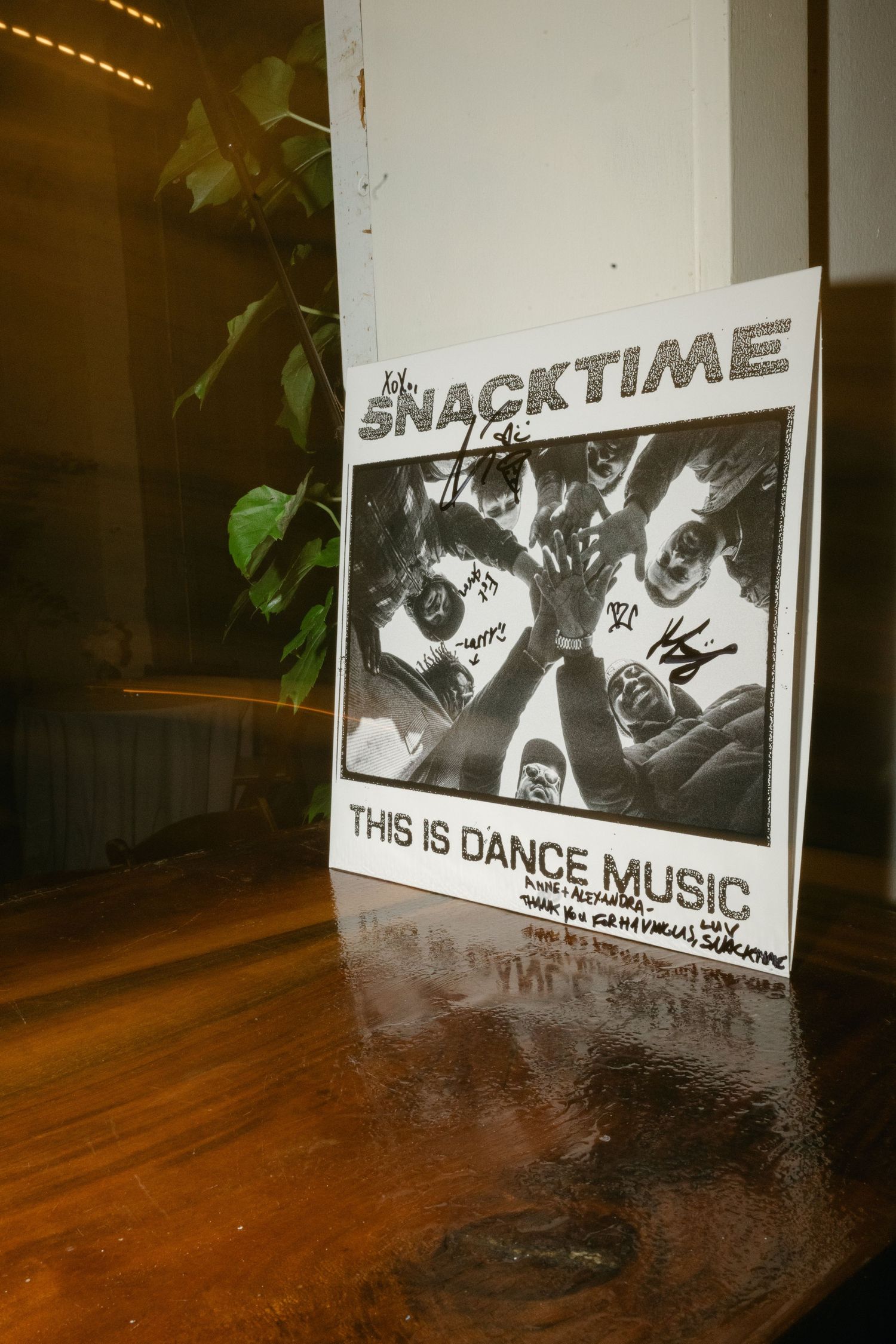 Black and white posters display text reading 'SNACKTIME' and 'THIS IS DANCE MUSIC' on a wooden floor.