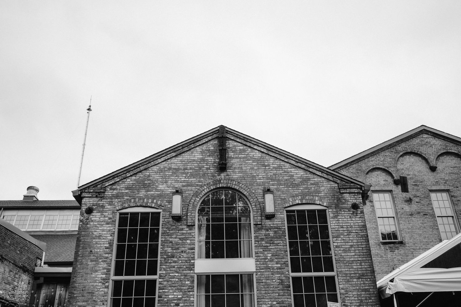 Black and white architectural photo of a historic brick building with arched windows.