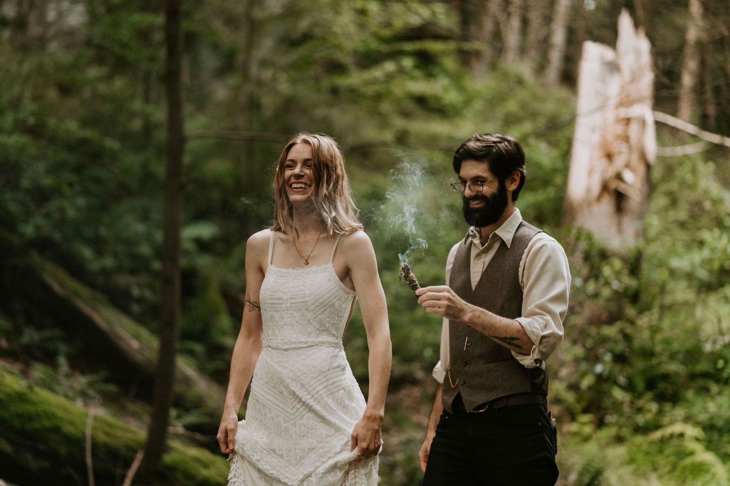A couple enjoys a celebratory moment in a misty forest setting.