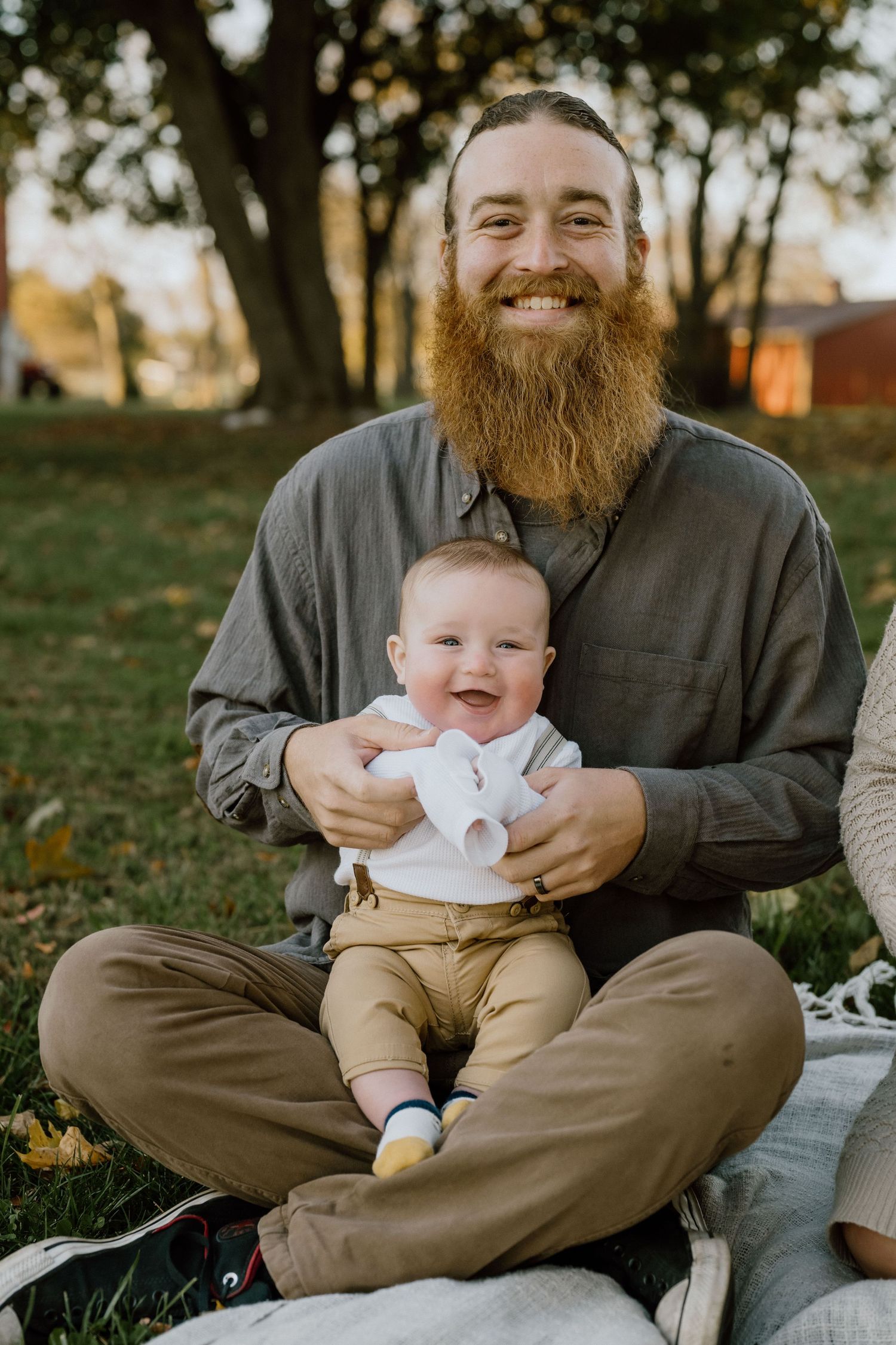 An outdoor portrait showing a warm moment on a blanket during autumn.