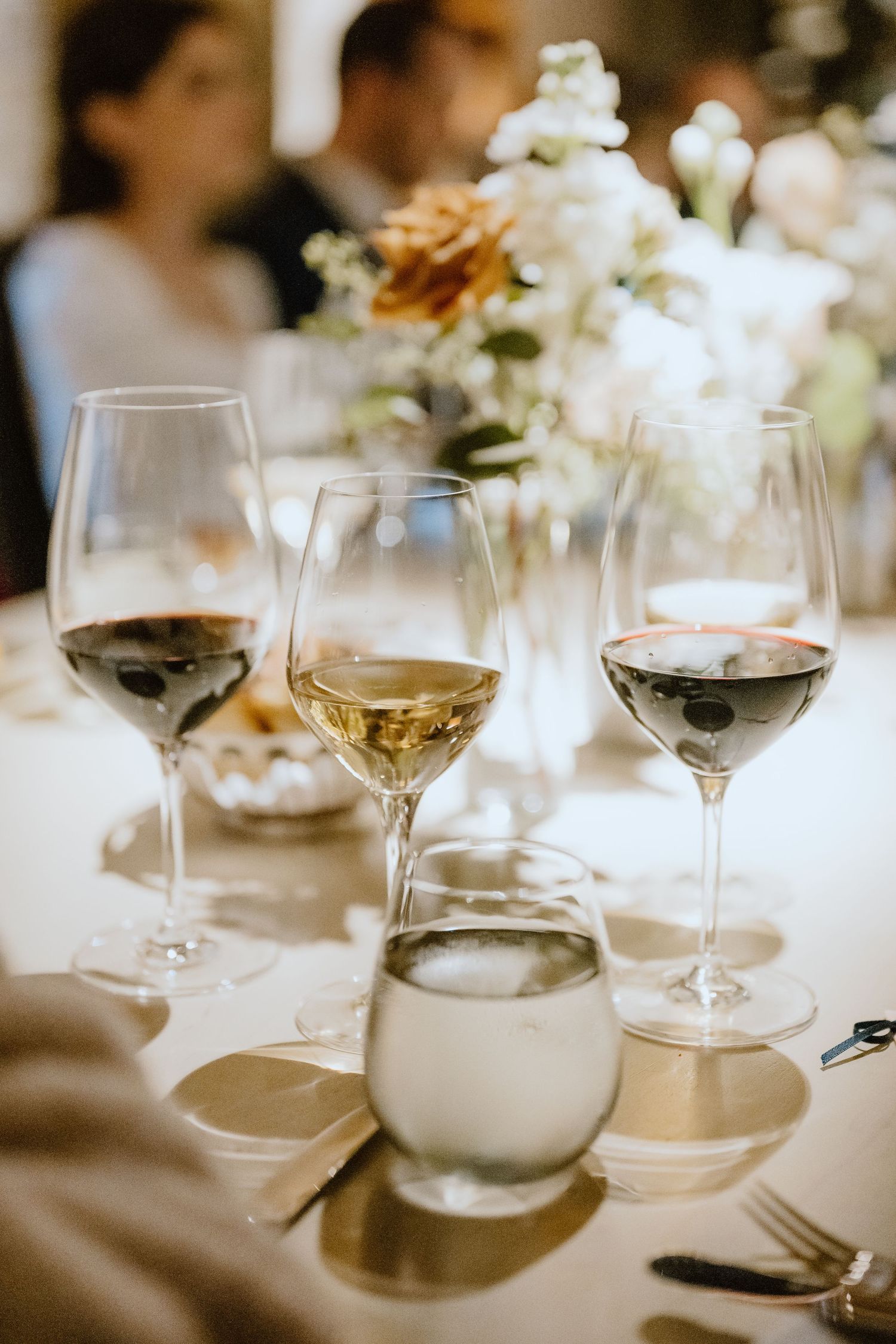 Wine glasses and floral centerpiece on an elegant wedding reception table.