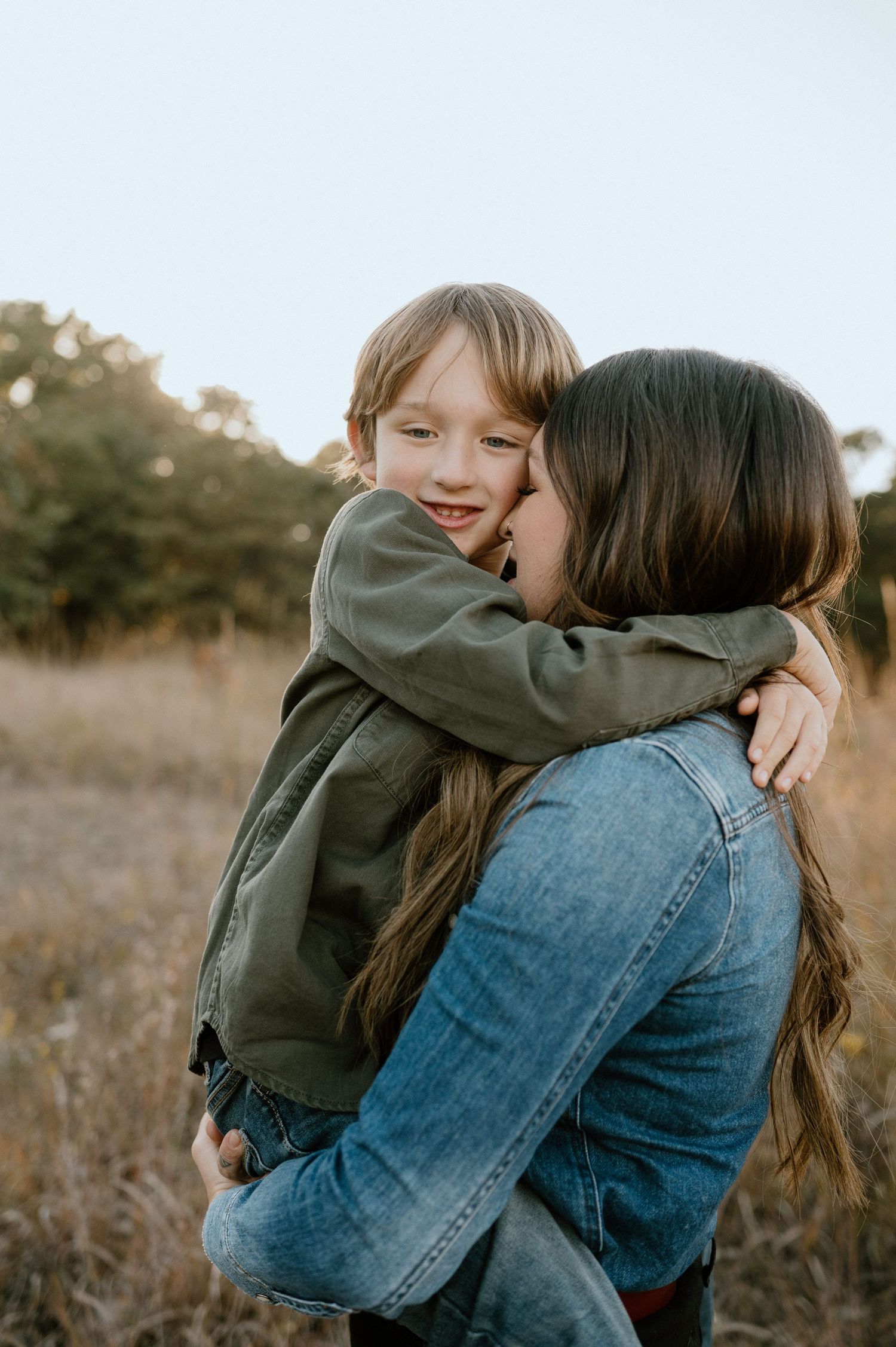 Candid moment of affection captured in natural outdoor setting.