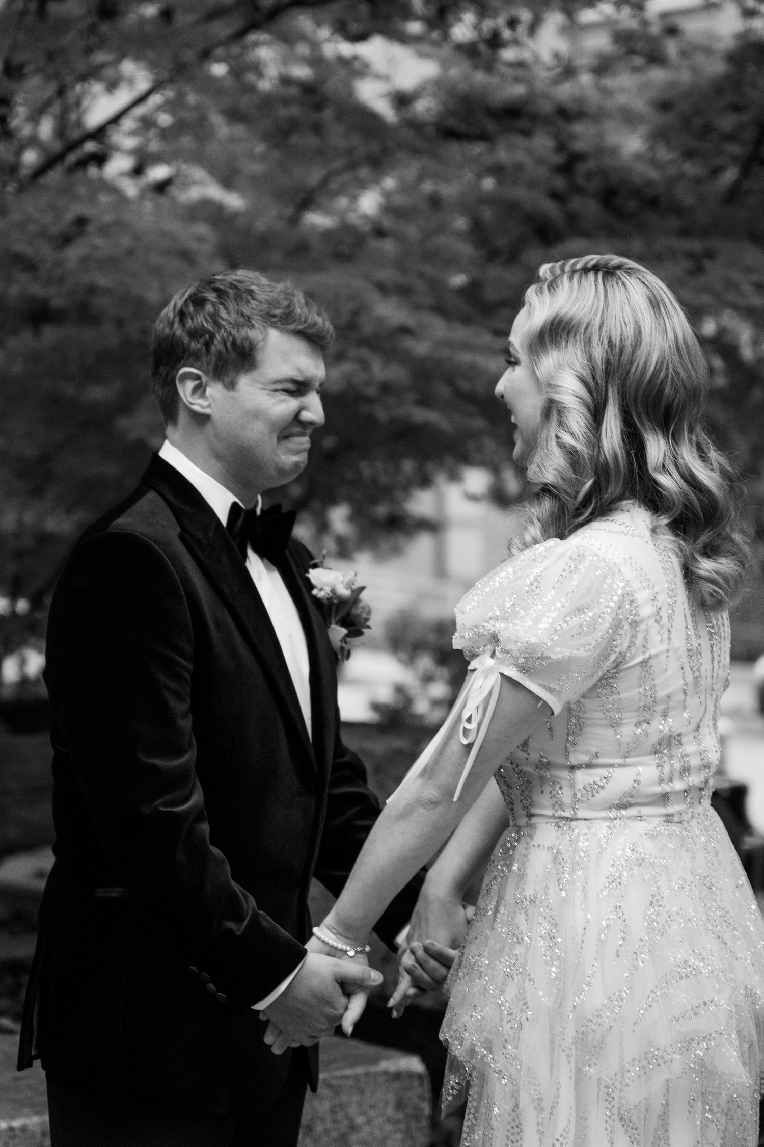 Wedding couple shares tender moments in a garden setting wearing formal attire.