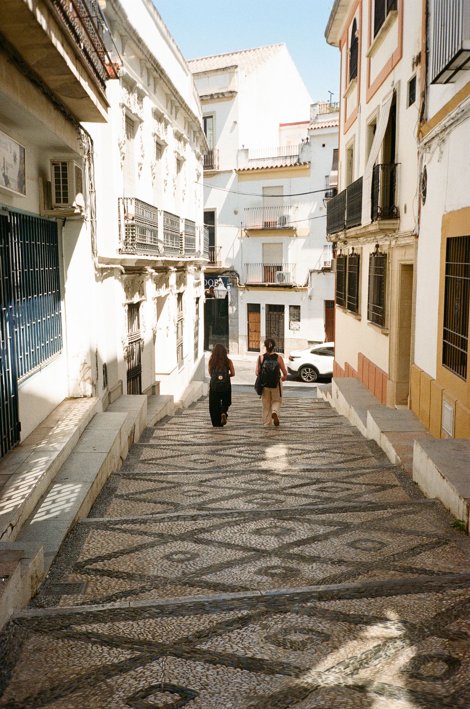 A charming street with decorative mosaic pavement and white buildings in Spain.