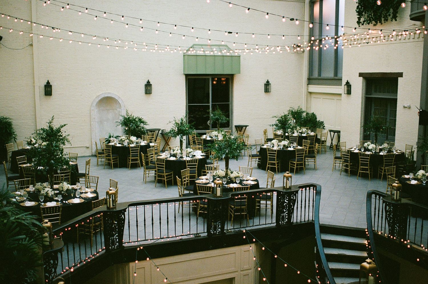 Wedding reception space decorated with string lights and white brick walls.