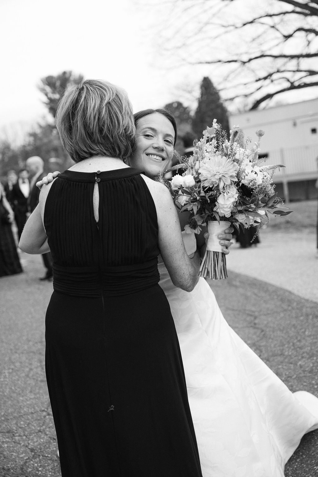 Black and white photo of wedding embraces outside a church building.