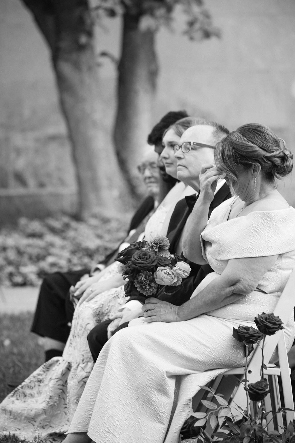 Black and white wedding photo sequence showing couple sharing a romantic kiss on a bench in a garden setting.