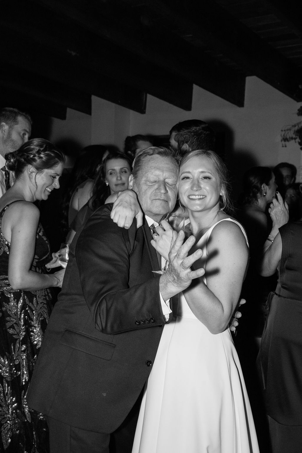 Black and white photo of couples dancing at an elegant wedding reception.