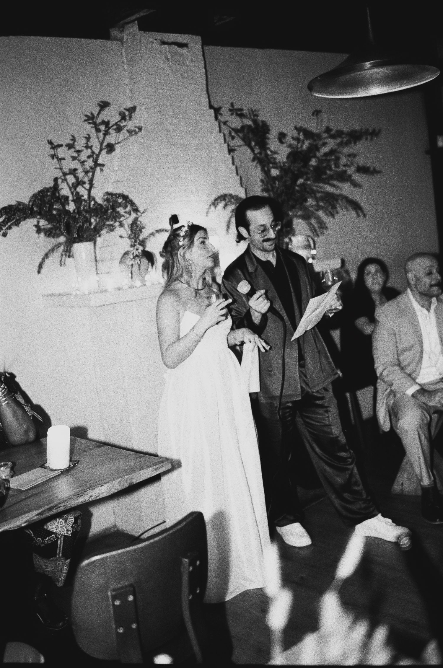 Candid black and white reception photos showing guests mingling and celebrating.