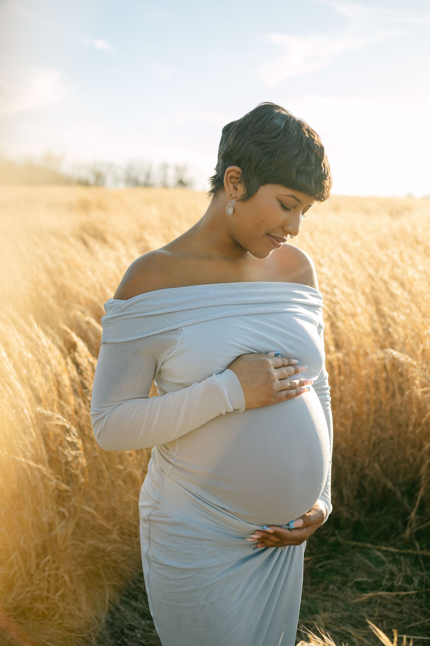 maternity photo of woman looking down at baby bump
