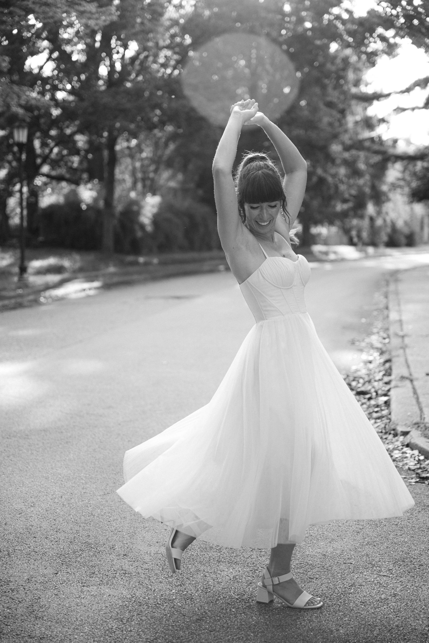 Black and white photo series of a flowing white dress twirling gracefully on a grassy path.