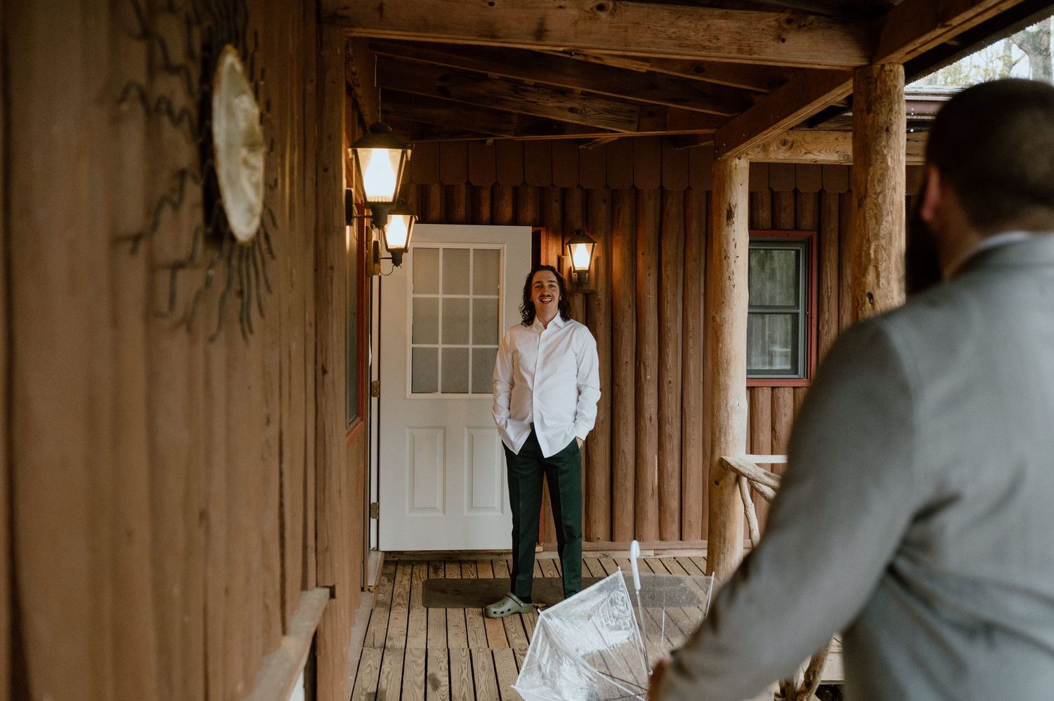 Two people sharing a quiet moment on a wooden cabin porch with warm lighting.