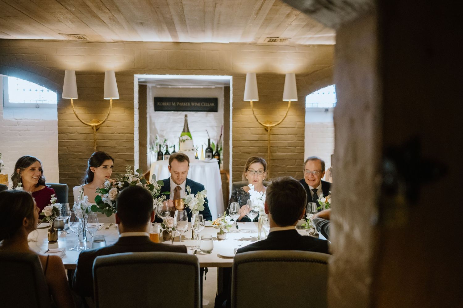 Elegant wedding reception dinner in a cozy restaurant with wood-paneled walls and ambient lighting.