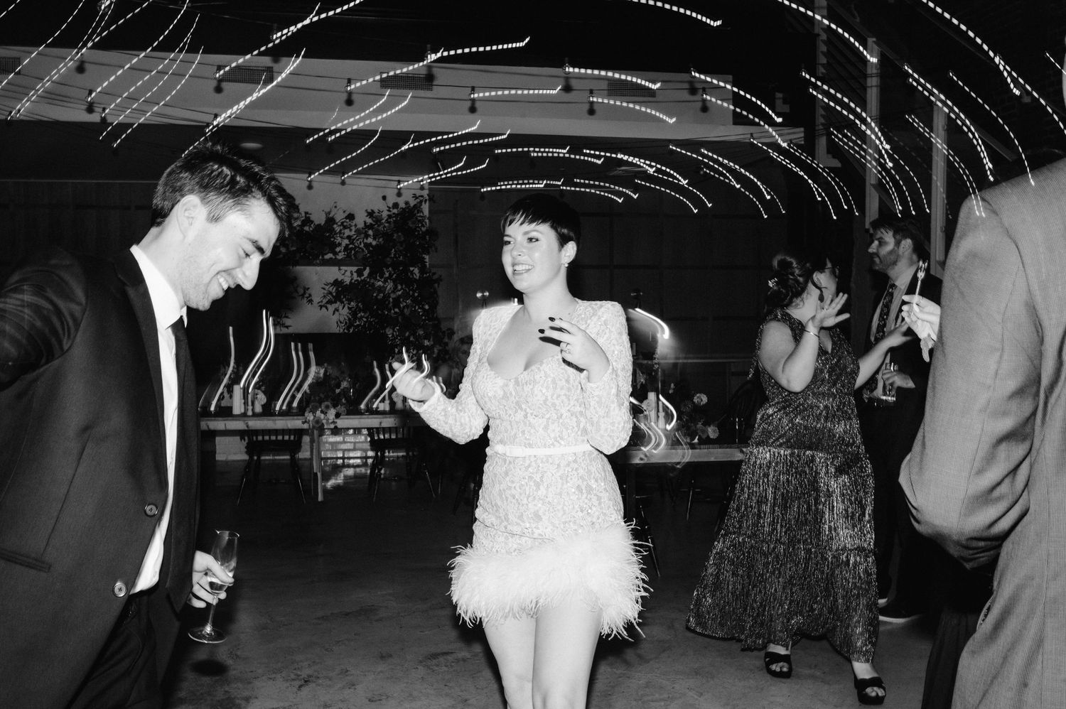 A retro black and white photo of people dancing at a party with vintage decor and lighting.