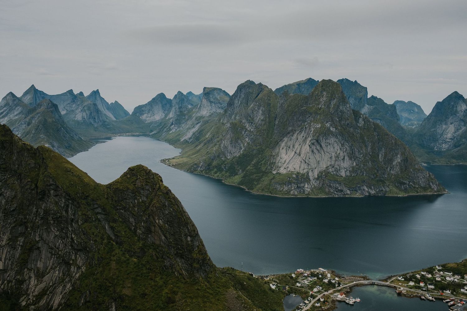 Dramatic fjord landscape with steep mountain peaks surrounding deep blue waters in Norway.