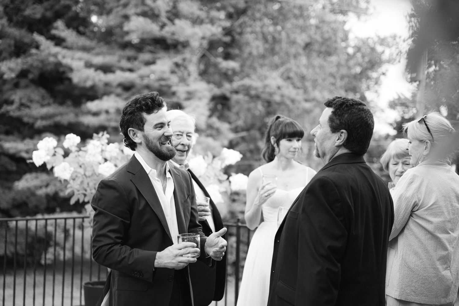 Guests mingle and chat during an outdoor wedding reception.