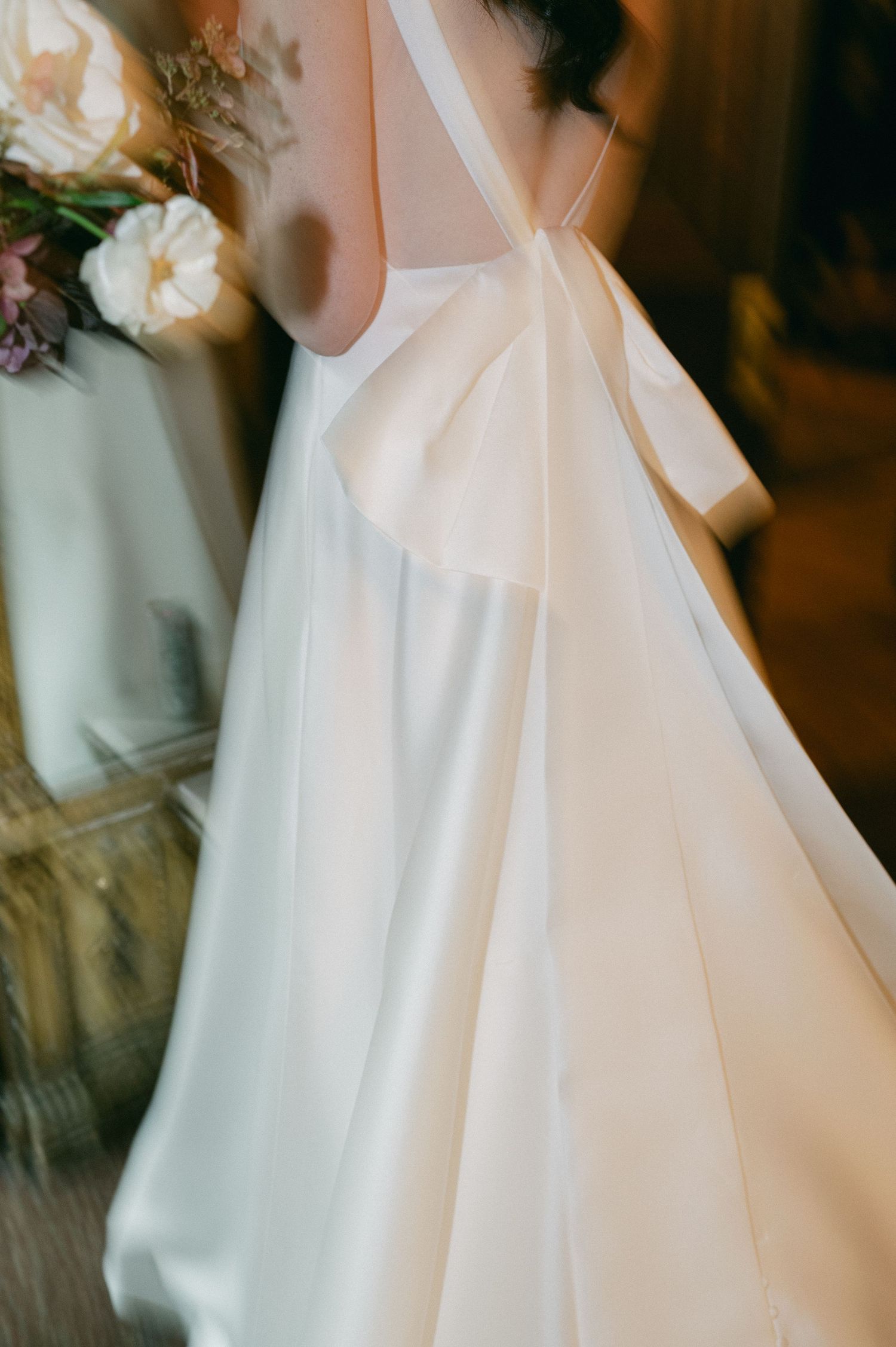 Close-up details of an elegant white wedding dress with delicate floral accents.
