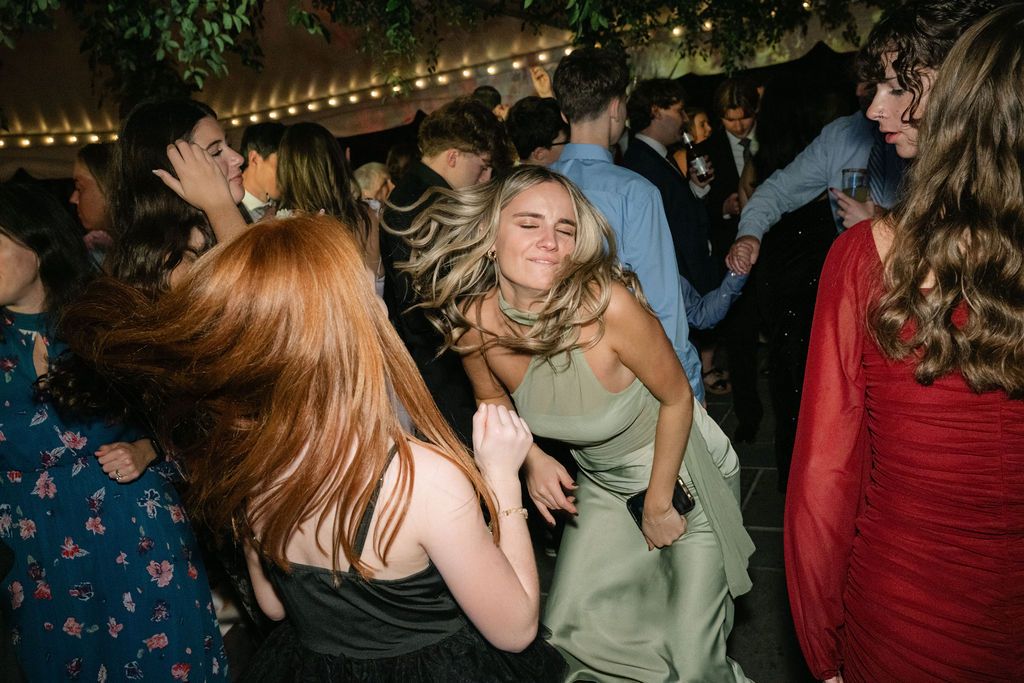 Wedding guests dance and celebrate under colorful party lights and decorative foliage at Strong Mansion on Sugarloaf Mountain
