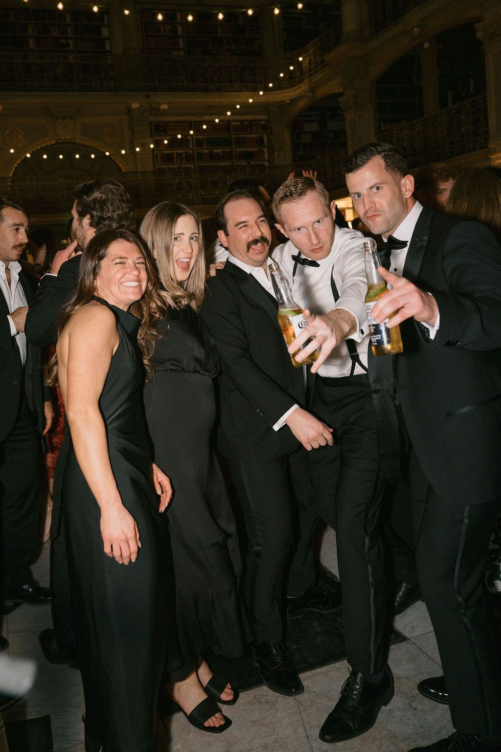 Party guests in formal attire dancing and celebrating at an indoor venue at George Peabody Library Wedding in Baltimore