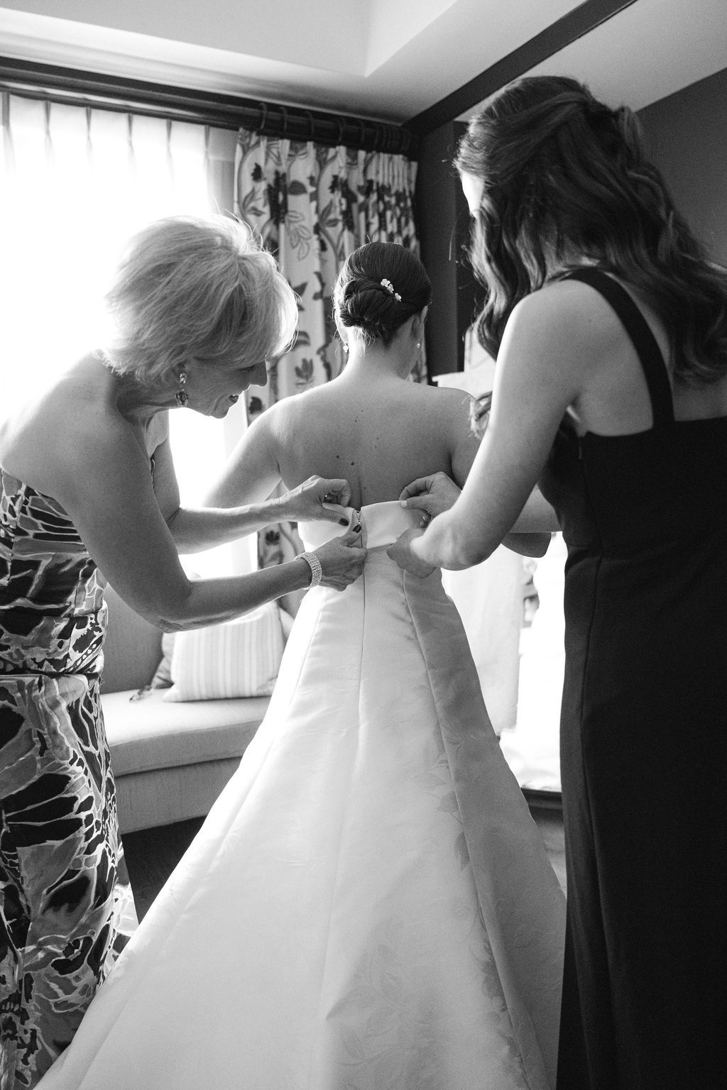 Wedding dress preparation sequence showing helpers assisting with white gown.