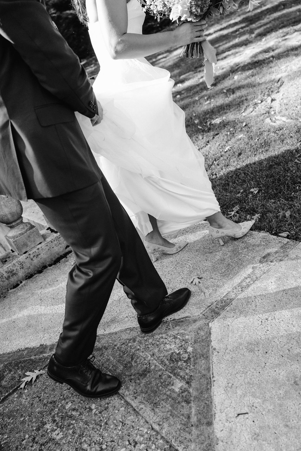 Black and white photo showing the movement of feet and dress hem during a wedding dance.