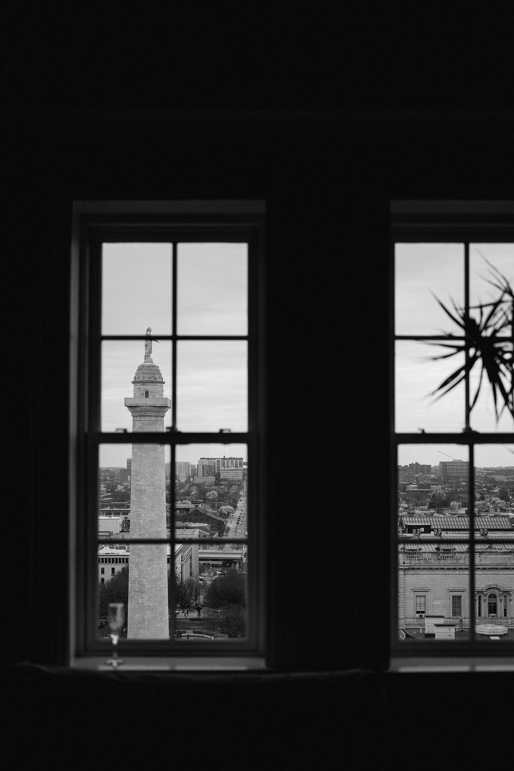 Black and white cityscape view through multiple windows showing a prominent tower.
