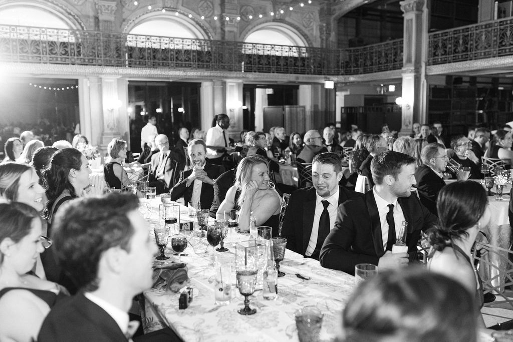 Wide view of an elegant wedding reception hall with ornate architecture and string lights at George Peabody Library Wedding in Baltimore