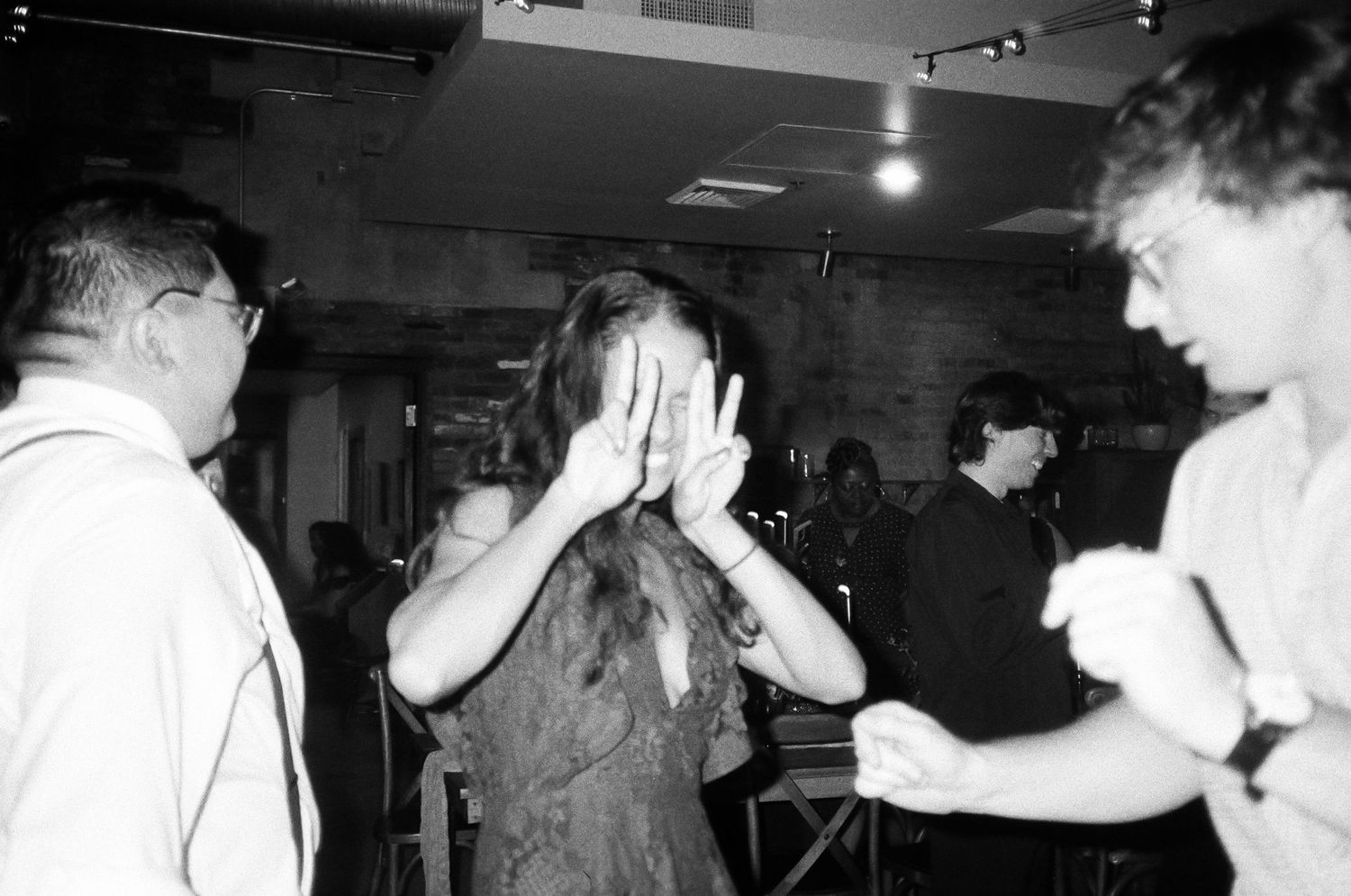 A black and white photo of people dancing at a lively party.