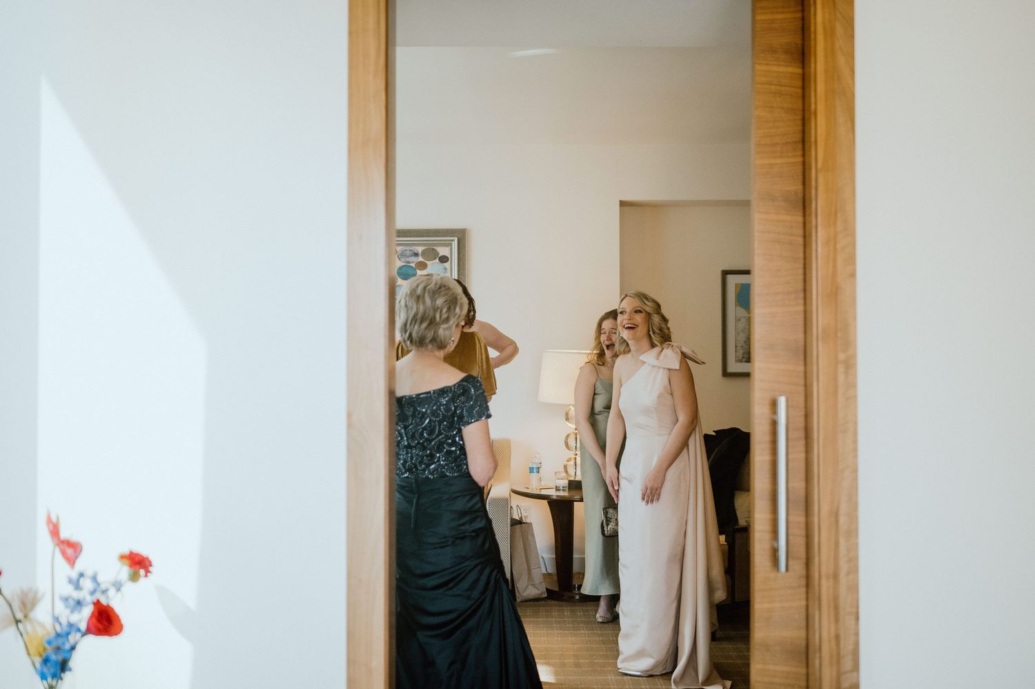 Wedding day preparation scene framed through doorway in natural light.