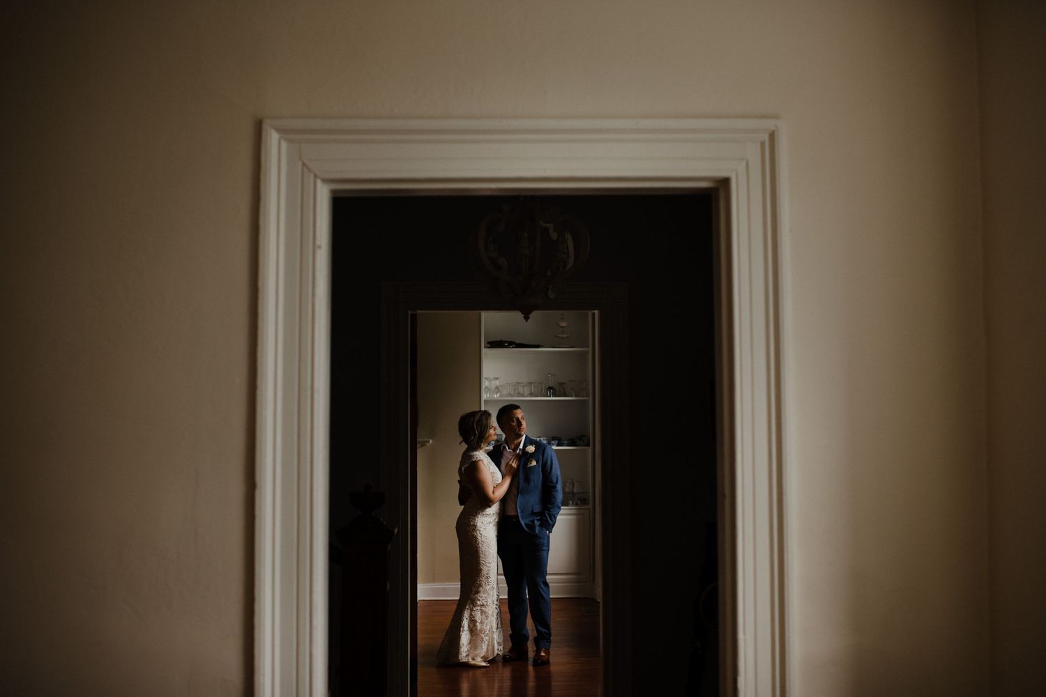 A dramatic silhouette through a doorframe creating an intimate wedding portrait.