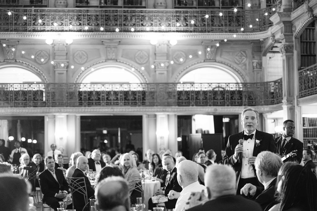 Guests enjoy an elegant evening reception under ornate architecture and chandeliers at George Peabody Library Wedding in Baltimore