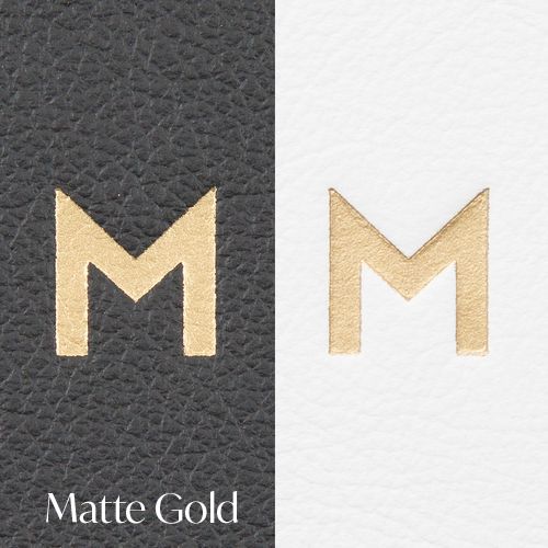 Design process showing gold metallic letter M logo variations from textured to matte finish on dark and light backgrounds.