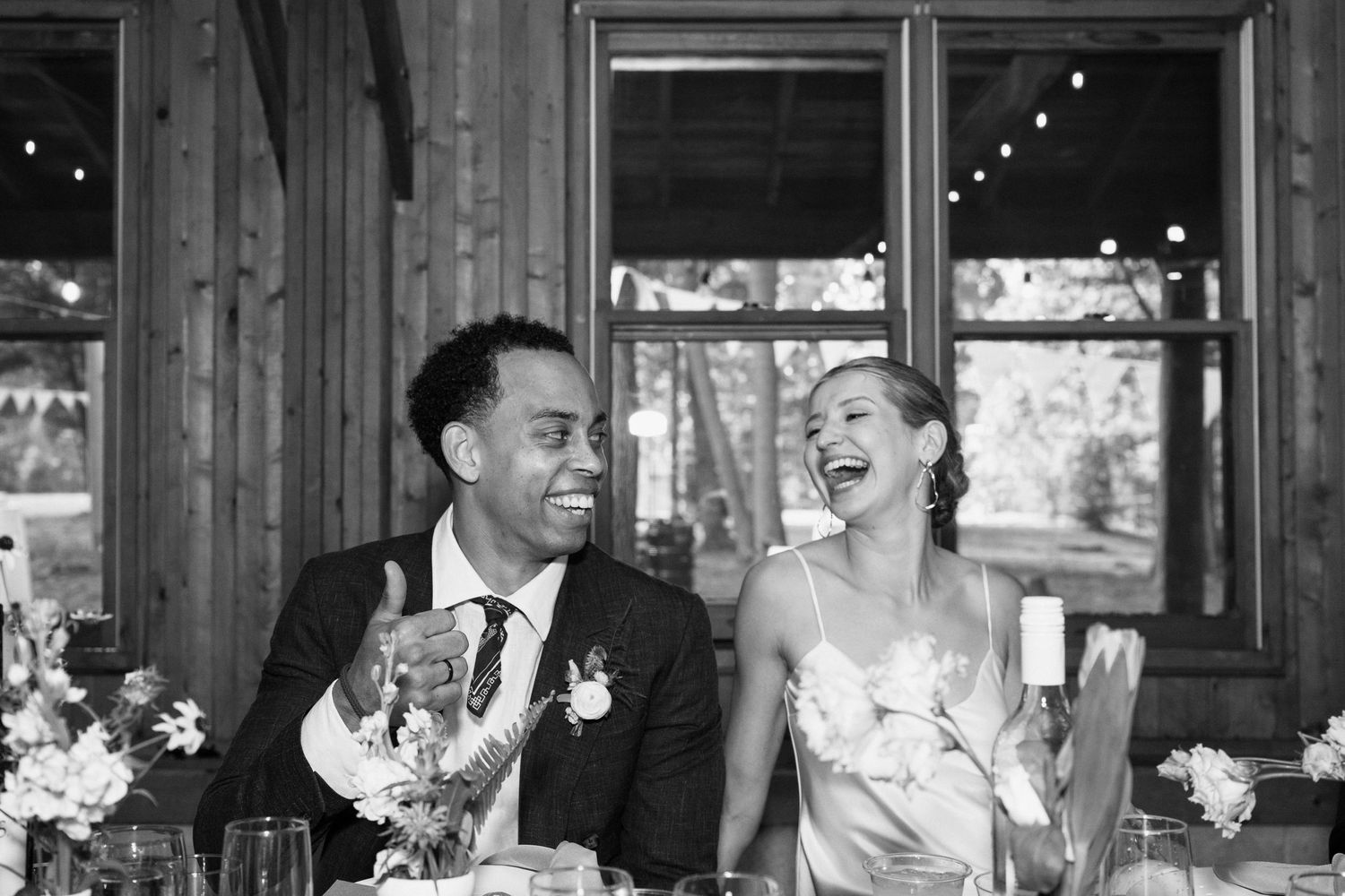 Candid moment of joy and laughter during reception dinner.