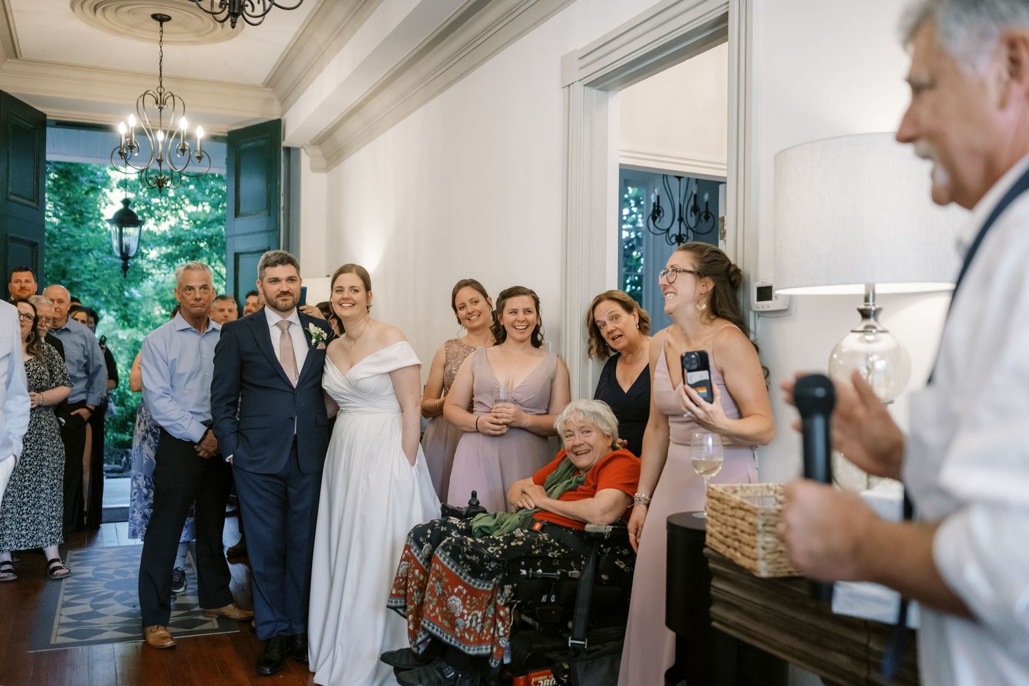 Wedding guests gathered indoors sharing stories and drinks during the reception celebration.