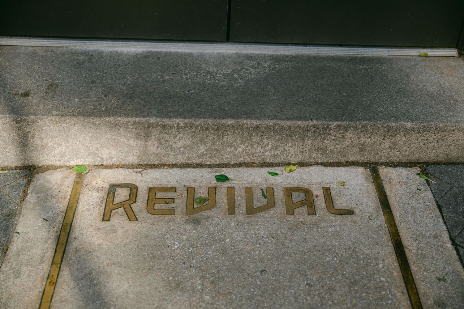 Close-up of the word 'Revival' engraved in concrete or stone.