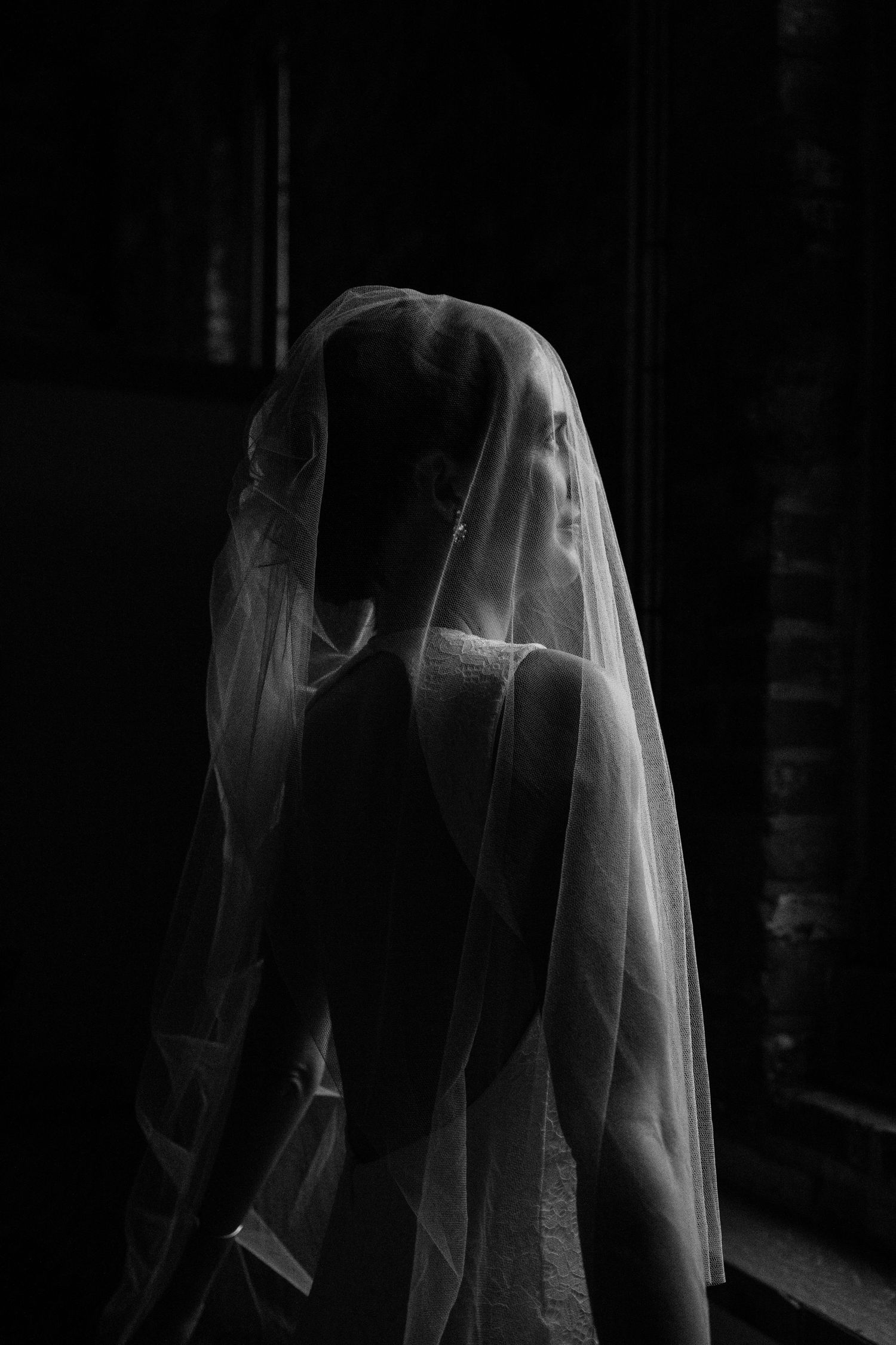 An artistic black and white portrait of a veiled figure creating a dramatic silhouette.