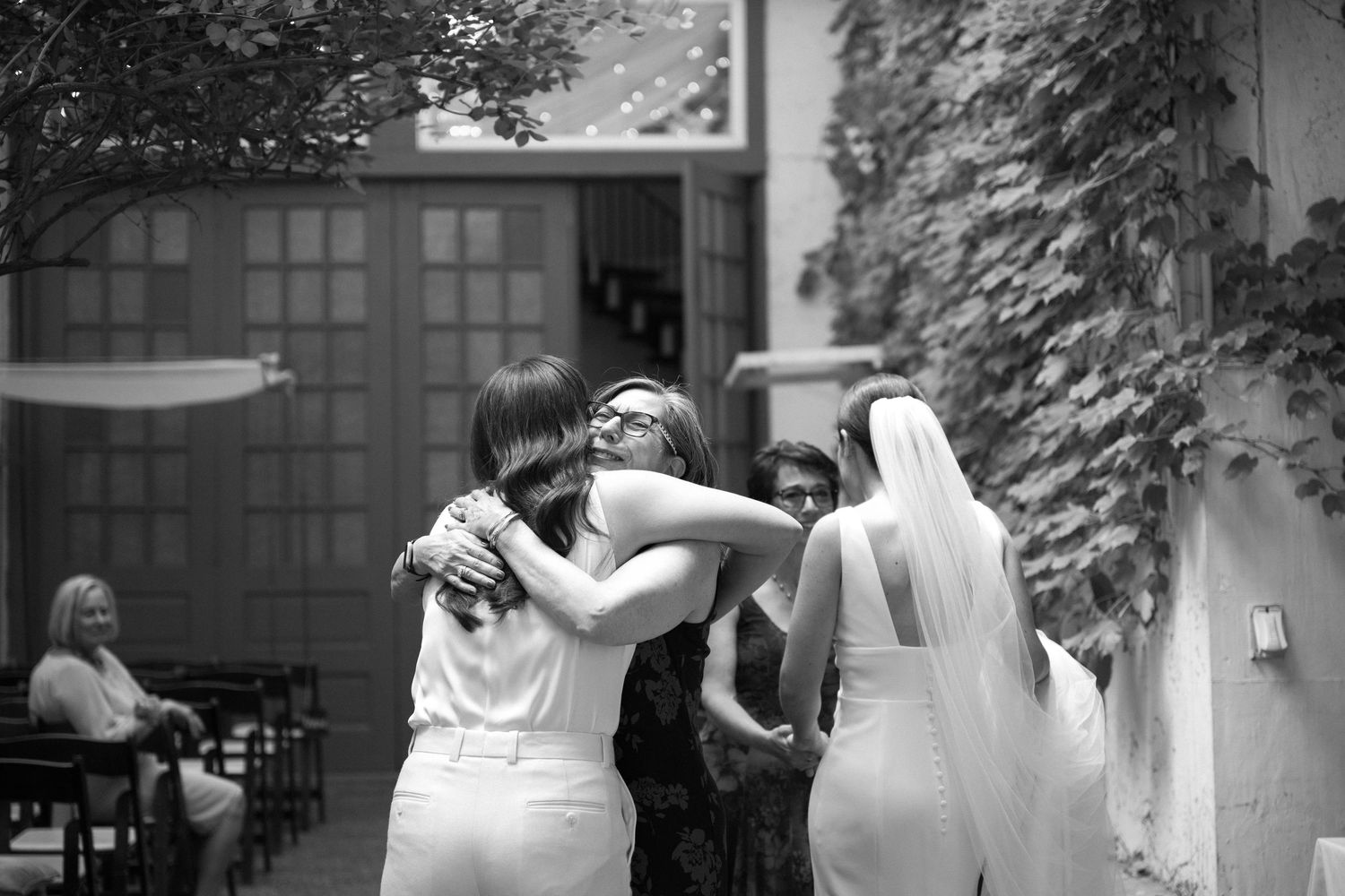 A black and white montage of wedding moments showing couples embracing and dancing during celebrations.