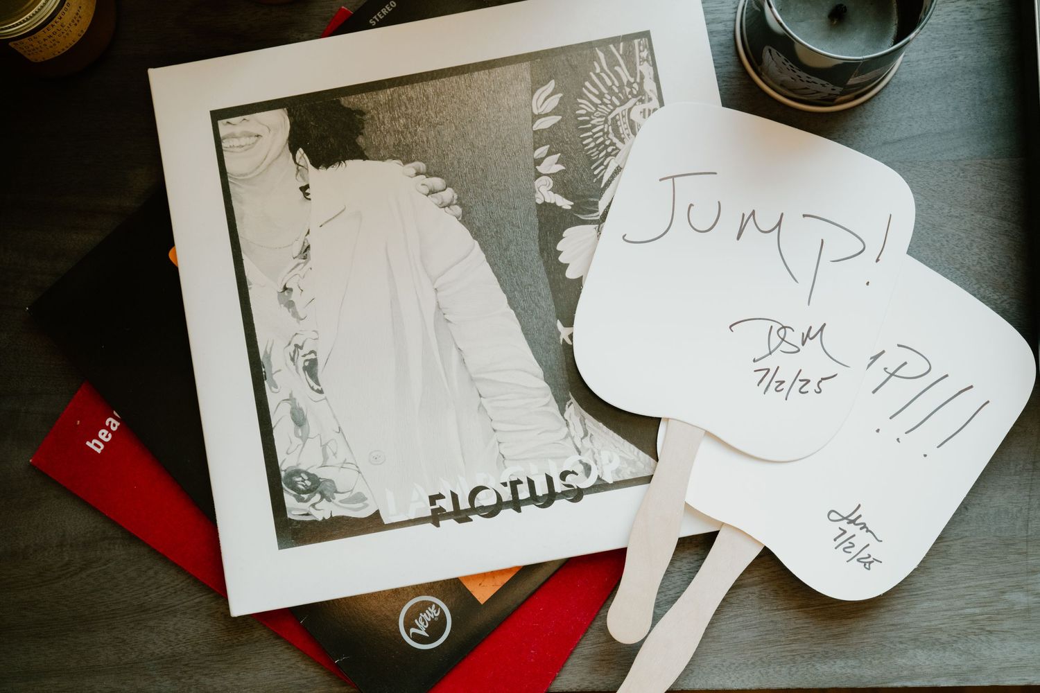 A vintage photo print alongside handwritten signs with the word 'JUMP' displayed on a dark surface.