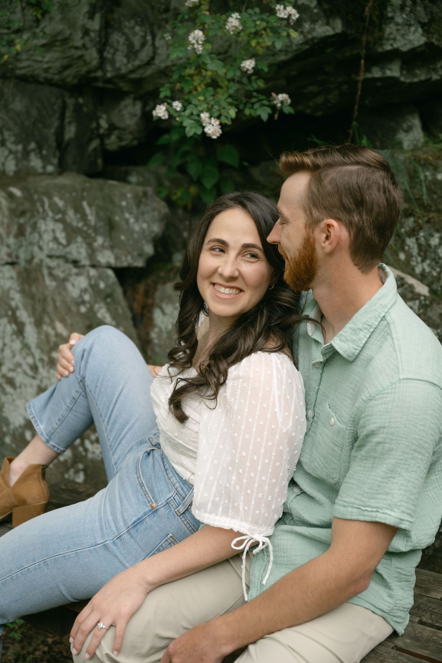 Couple sharing intimate moments against a rocky cliff backdrop.