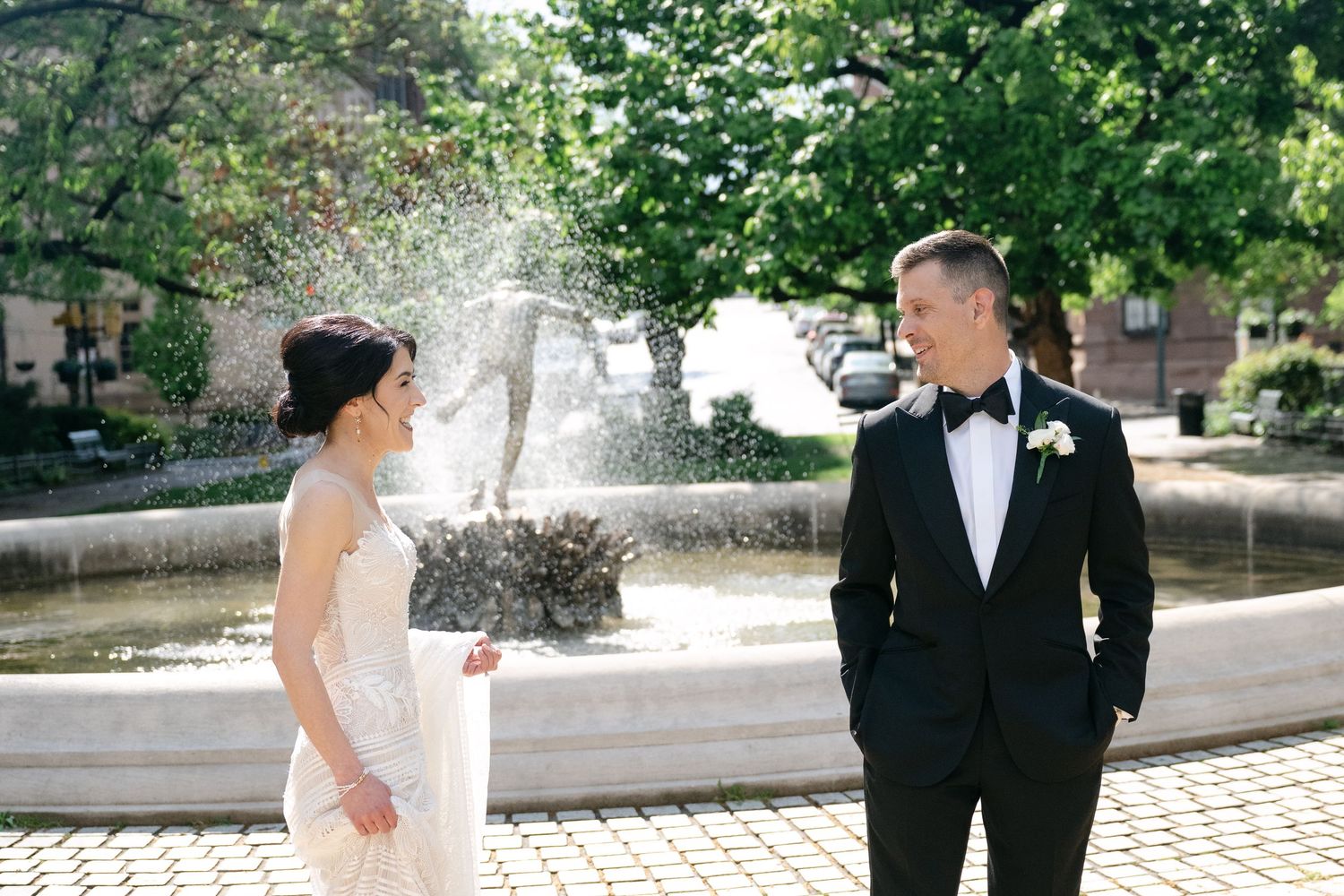 Wedding couple poses for portraits in an elegant outdoor courtyard setting.