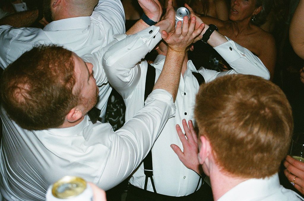 Wedding guests dancing and celebrating enthusiastically during the reception party.