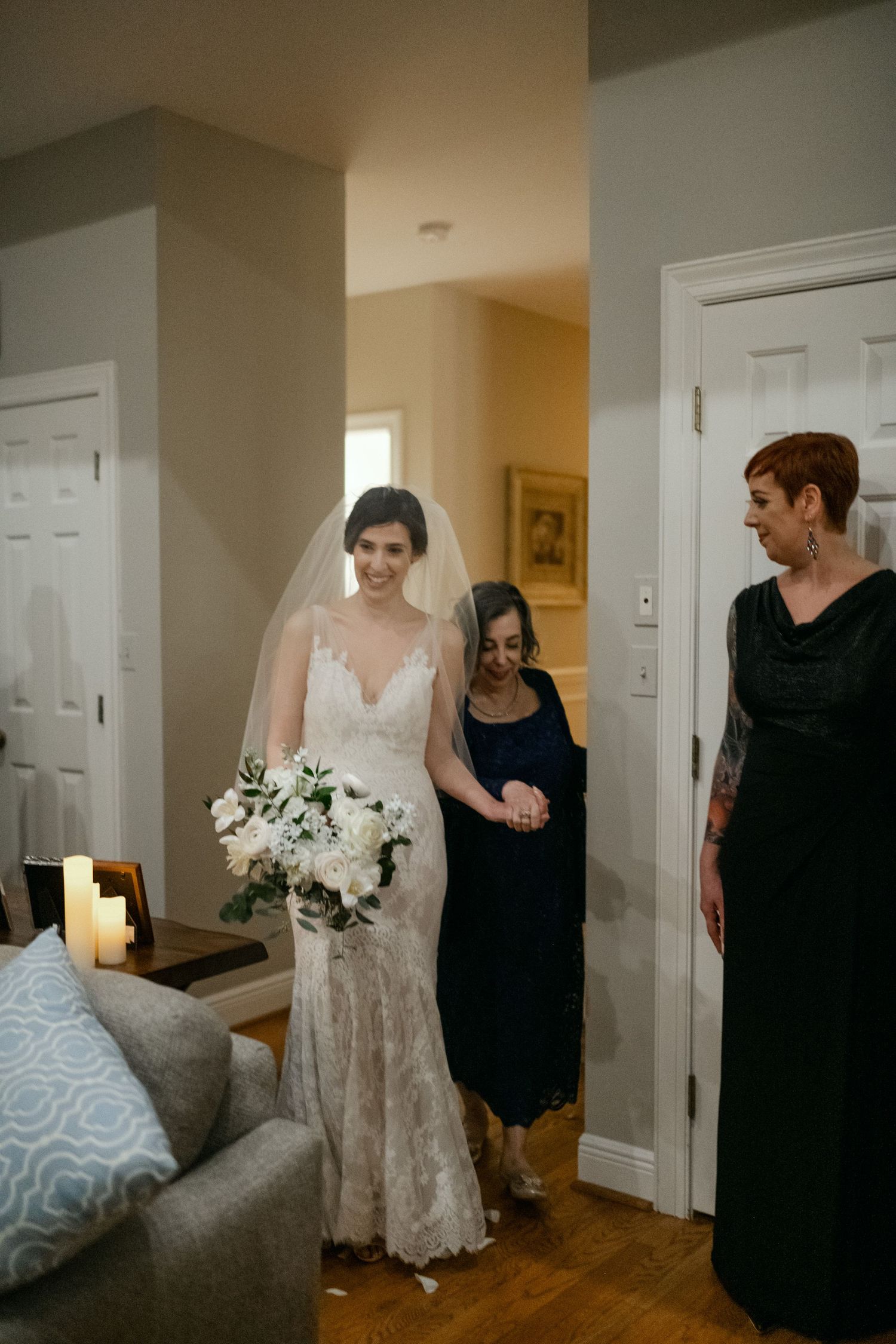 Elegant bridal preparation scene in a home with white floral bouquet and candlelight.