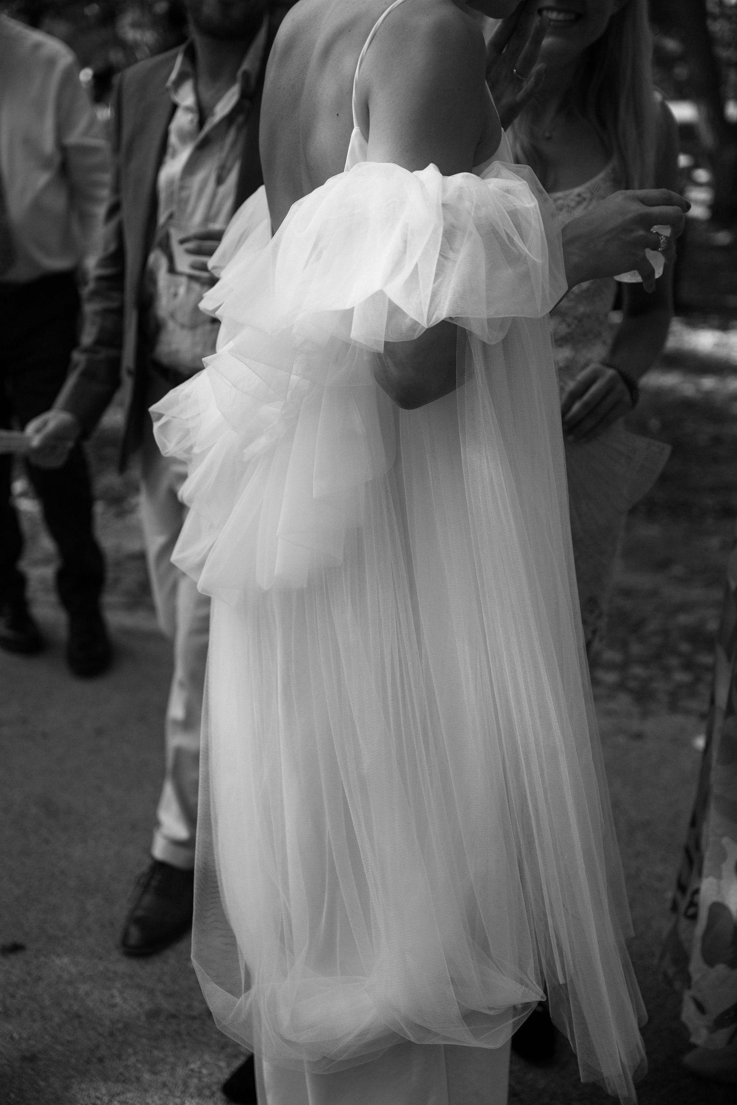 Close-up detail of a flowing white wedding dress with delicate tulle layers.