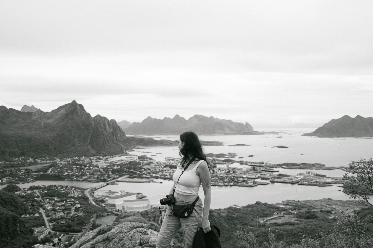Scenic overlook of coastal town nestled between mountains and fjords.
