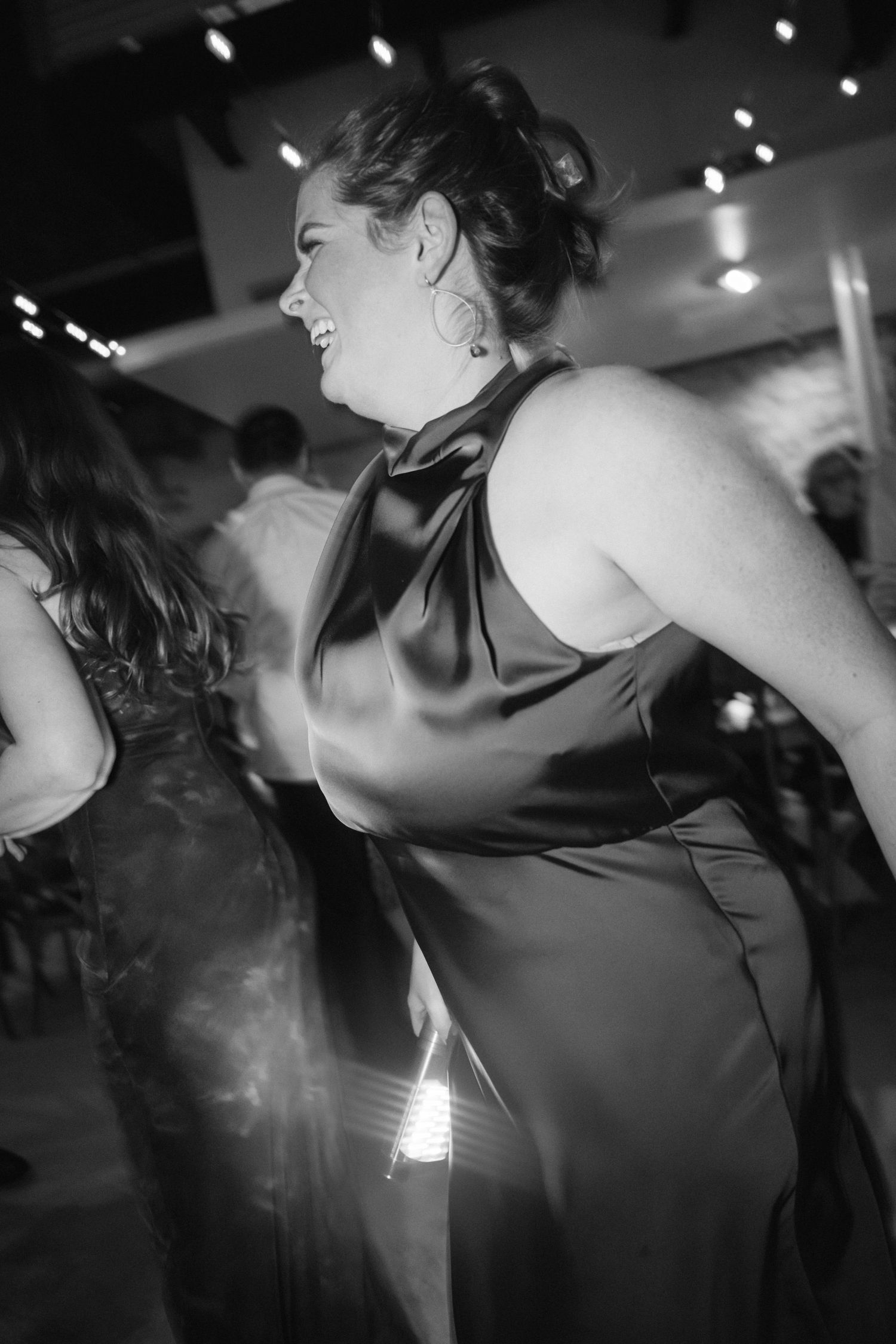 Black and white photo of someone dancing at an evening celebration.