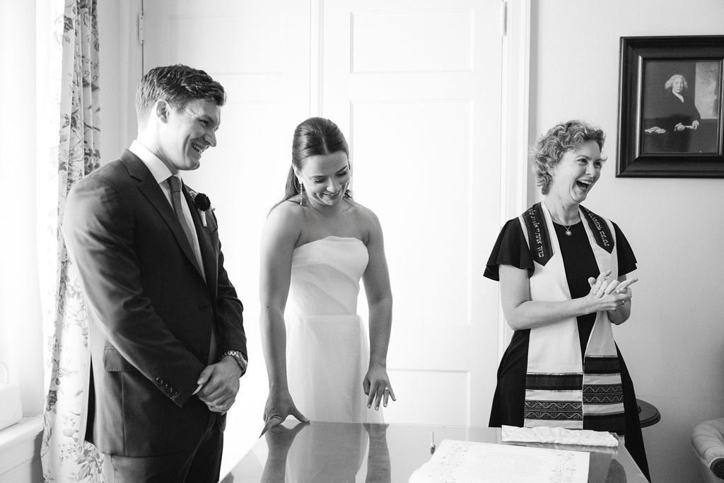 Black and white candid wedding preparation moments in an indoor setting.
