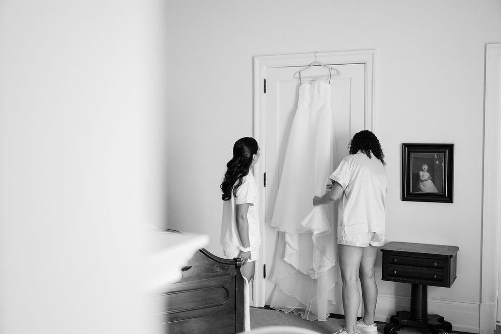 Black and white image showing preparation of formal attire in a bedroom setting.