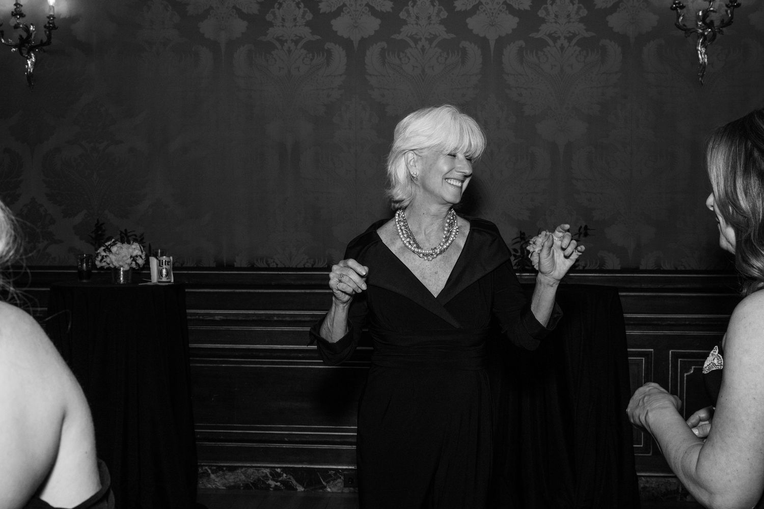 Black and white candid photo of elegant wedding reception gathering.